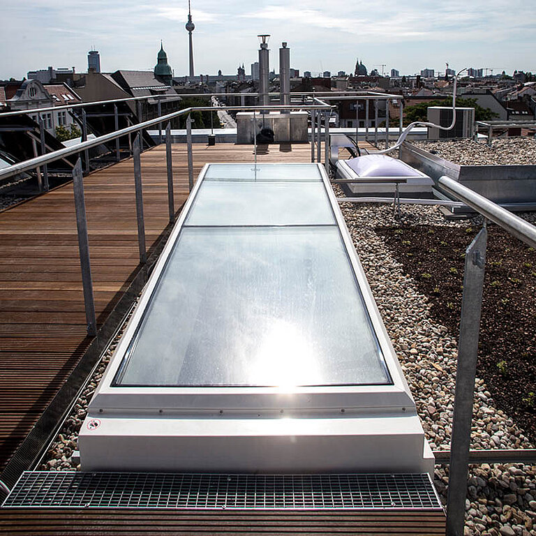 Geschlossener LAMILUX Flachdach Ausstieg Komfort Solo mit flächenbündiger Verglasung auf Dachterrasse und umlaufendem Geländer