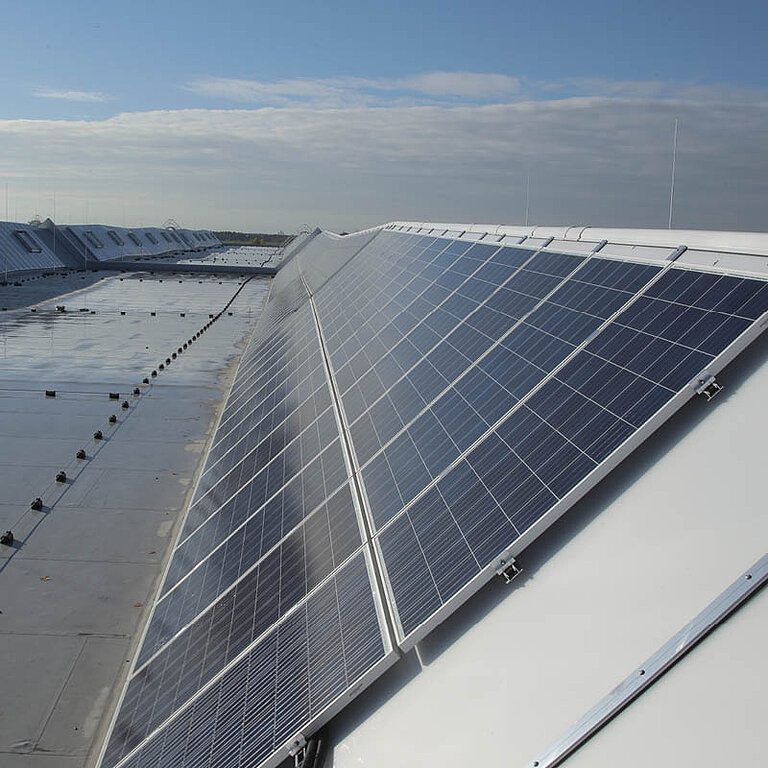 LAMILUX Lichtband mit Photovoltaik auf Flachdach mit geneigter Verglasung