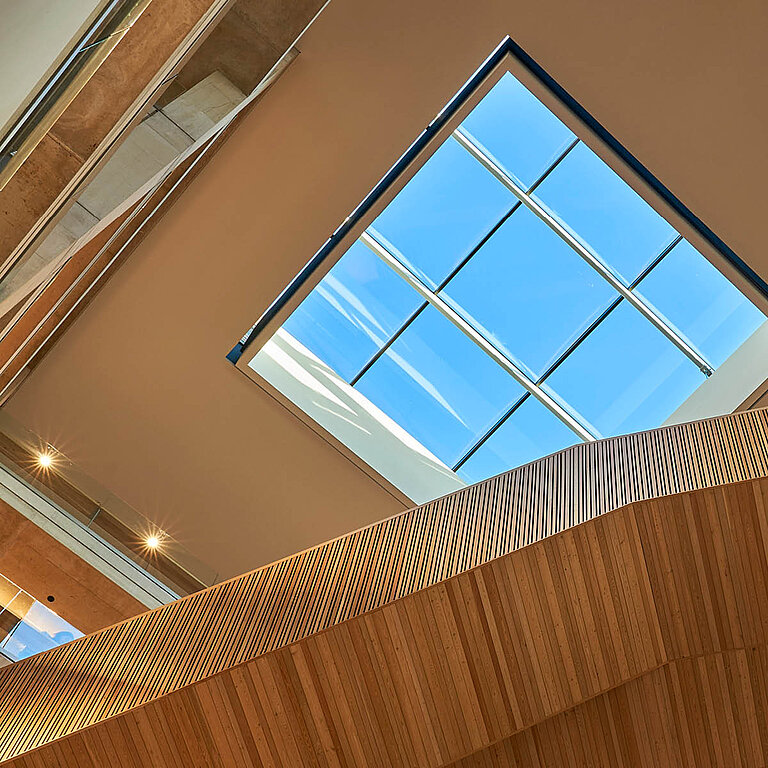 Innenansicht eines Glass Roof PR60 Passivhaus mit rechteckiger Öffnung und klarem Himmel.