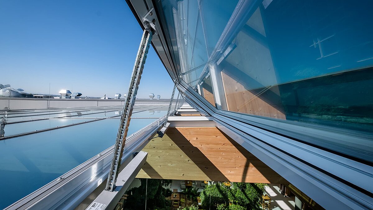 Detailansicht des modernen Öffnungssystems der Glasdachkonstruktion im Naturkostladen Byodo in Mühldorf, das für optimale Belüftung sorgt.
