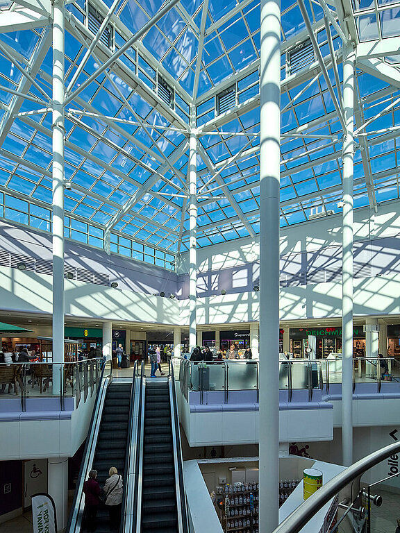 LAMILUX Glasdach in einem Einkaufszentrum mit Tageslicht, Säulen und Rolltreppen