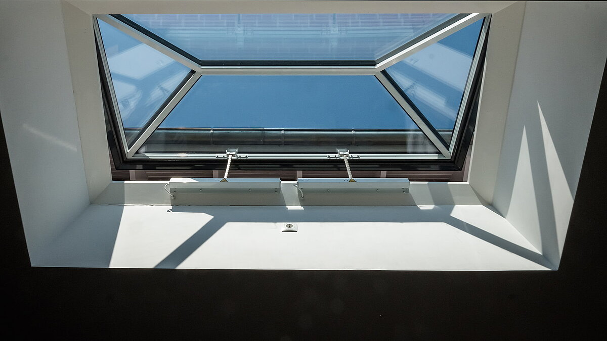 Innenansicht eines Flachdachfensters von LAMILUX in einem Wohnhaus in Hamburg, das für viel Tageslicht sorgt.