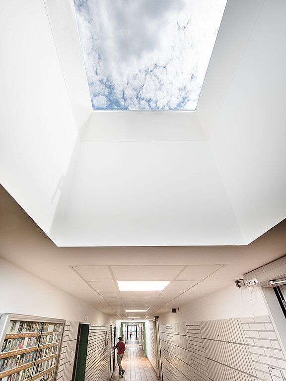Flachdach-Fenster im Caritas-Gebäude Hagen, mit Blick auf den Himmel und dem lichtdurchfluteten Flur.