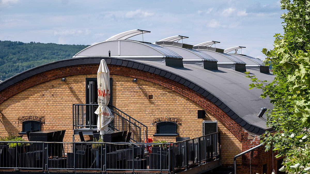 Außenansicht der Kletterhalle "Alte Brauerei" in Eisenach mit LAMILUX Lichtbändern B auf dem gewölbten Dach.