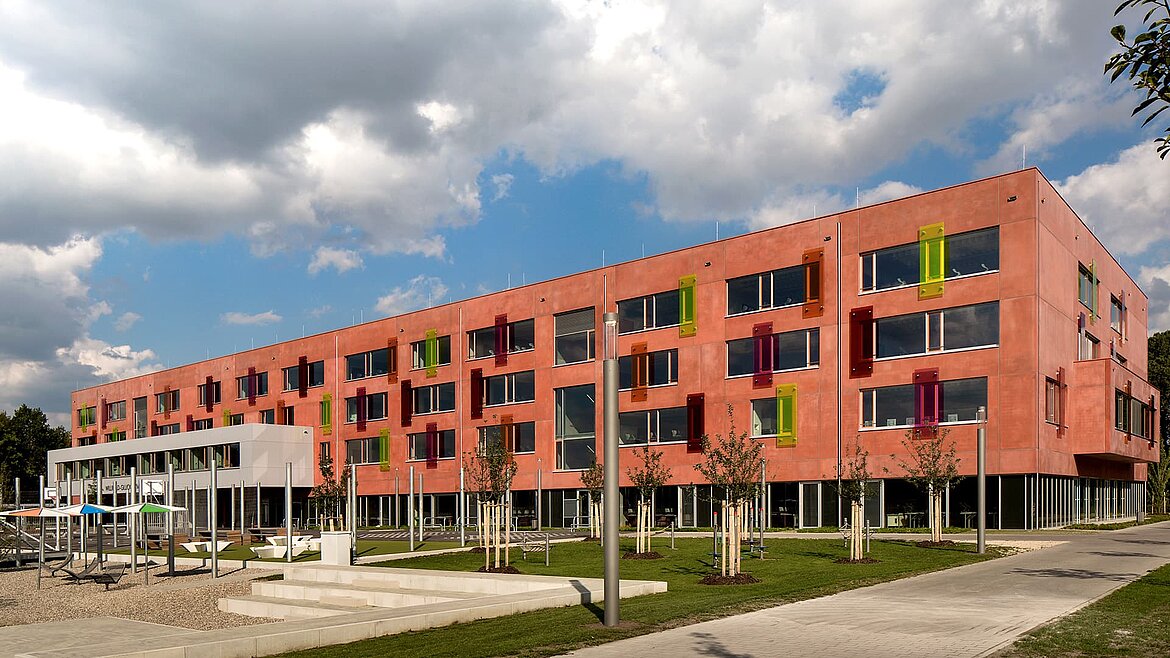 Außenansicht des Willibald-Gluck-Gymnasiums in Neumarkt mit farbenfrohen Fassadenelementen und modernem Design.