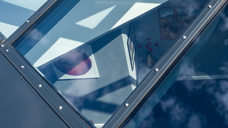 Detailansicht des Glasdachs PR60 Passivhaus mit Reflexionen und sichtbarer Verschraubung.