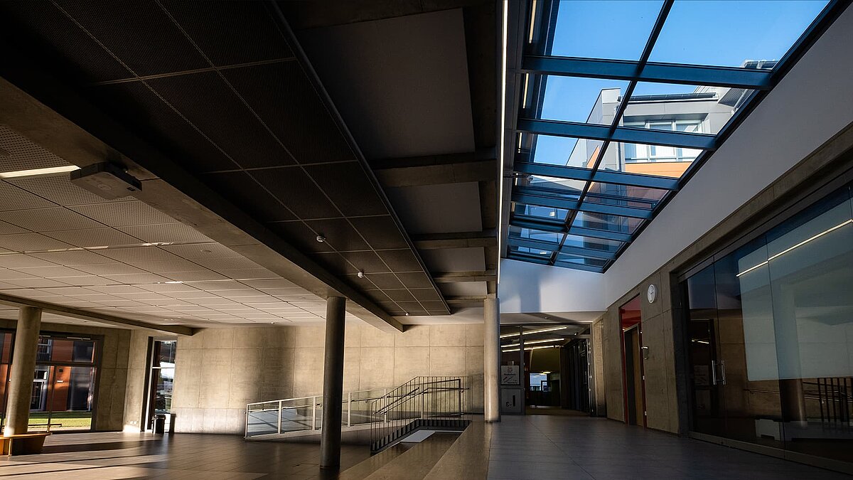 Innenbereich des Schulzentrums Rehau mit modernem LAMILUX Glasdach PR60, das Tageslicht in den Raum bringt.