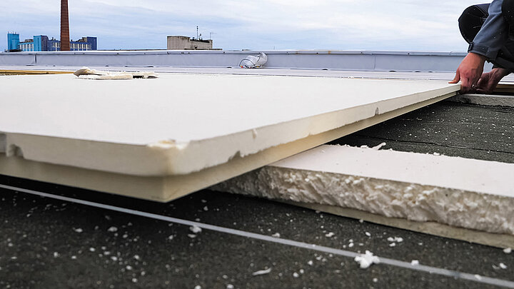 Flachdach mit verlegten Dämmplatten im mehrschichtigen Dachaufbau während der Montage