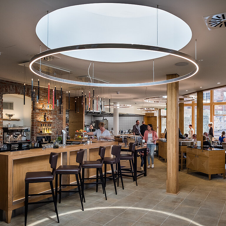 LAMILUX Flachdach Fenster FE rund im Restaurant, große runde Tageslichtöffnung über Sitzbereich