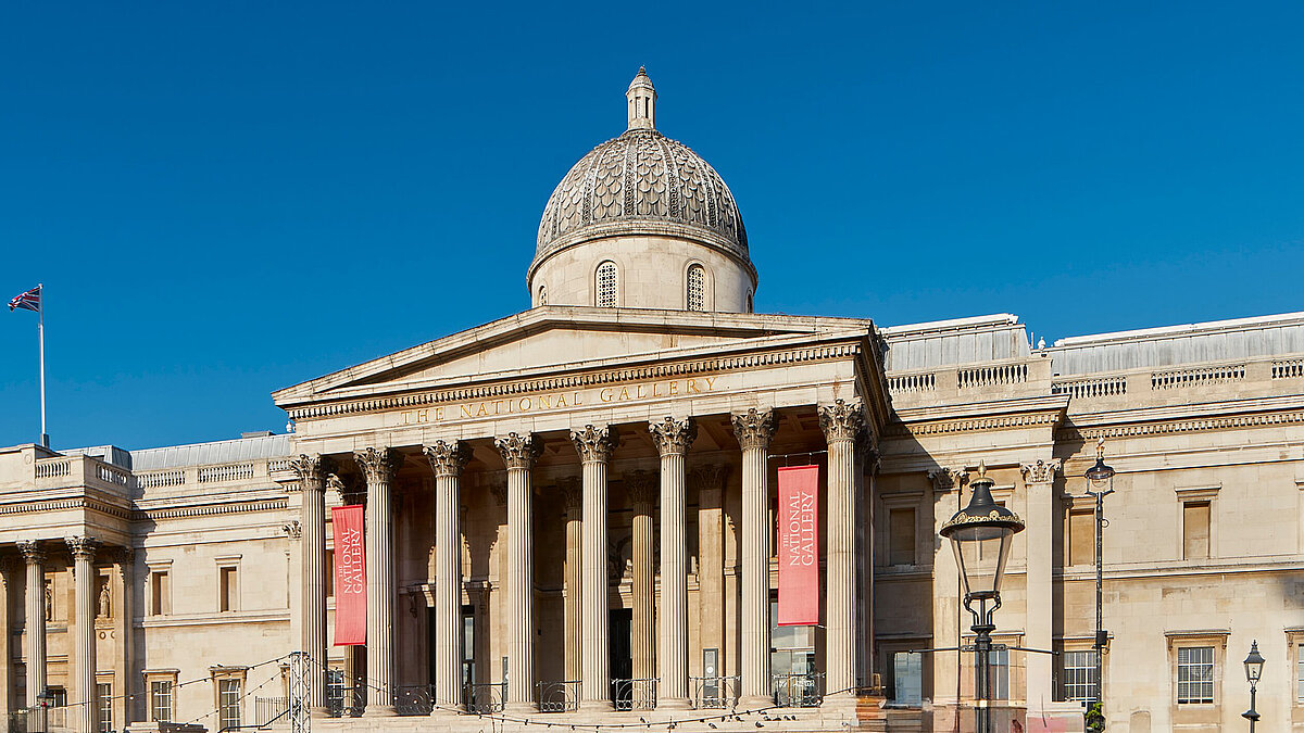 Historisches Gebäude mit großer Kuppel und Säulen bei blauem Himmel