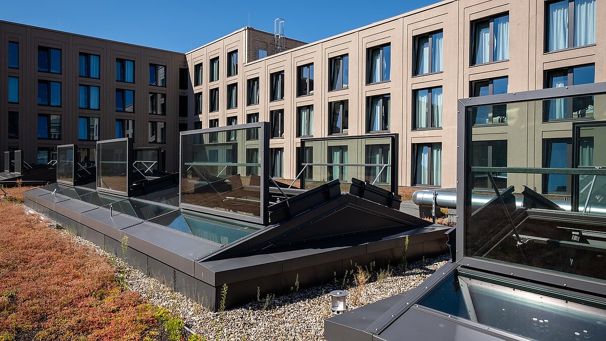 Offene Glasdächer von LAMILUX auf dem begrünten Dach des Schultheiss Quartiers in Berlin-Moabit.
