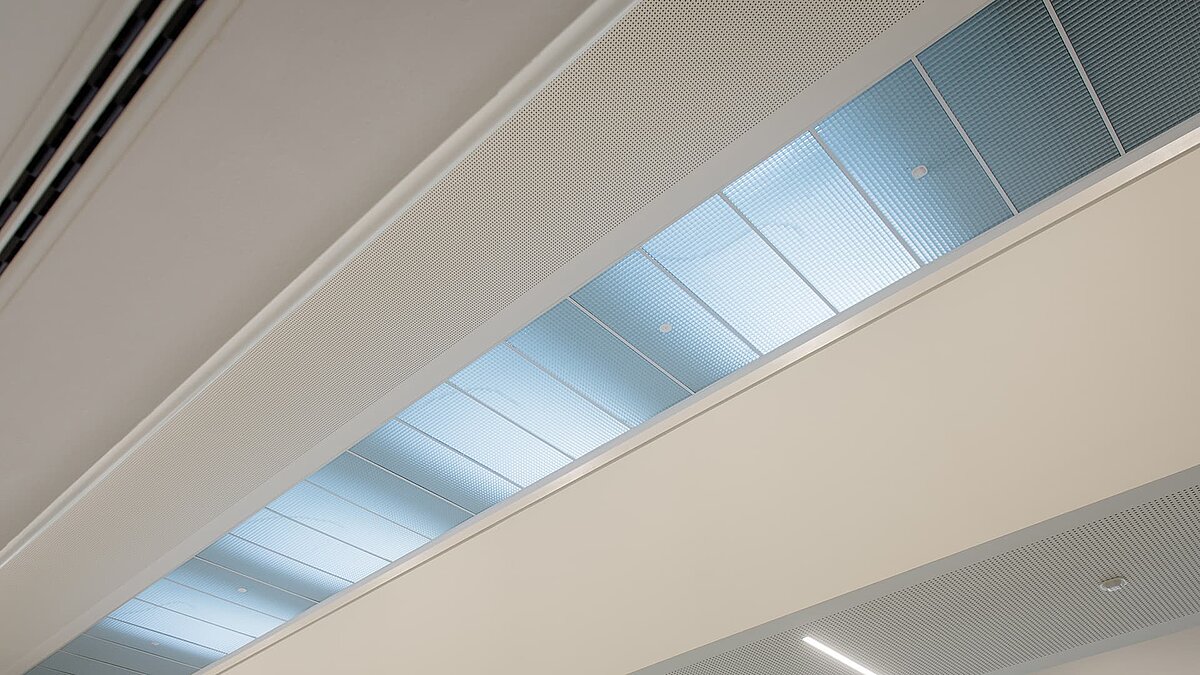 Innenansicht eines Flachdach-Fensters im Markgraf-Georg-Friedrich-Gymnasium in Kulmbach, mit blau getöntem Glas für natürliches Licht.