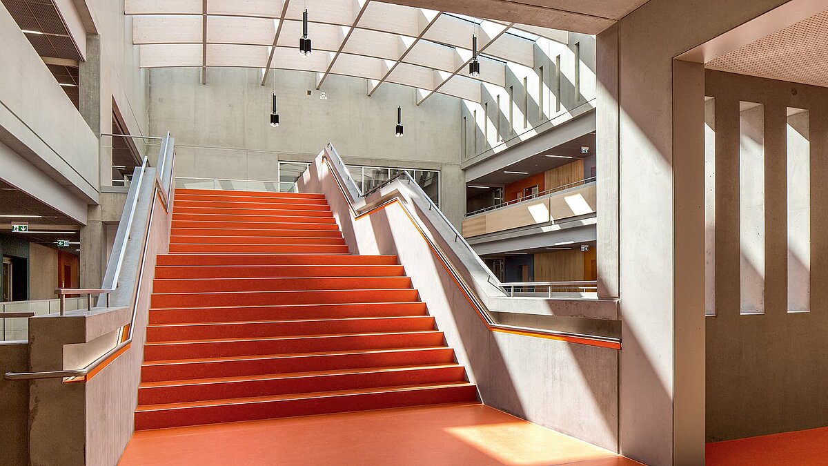 Treppenaufgang im Willibald-Gluck-Gymnasium in Neumarkt, beleuchtet durch LAMILUX Glasdächer.