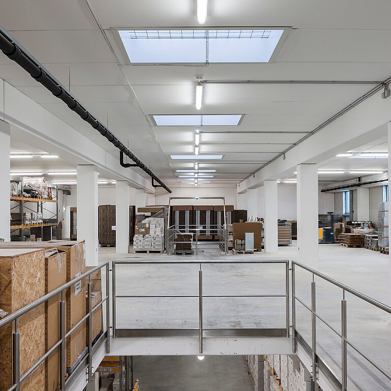 Innenansicht einer Industriehalle mit LAMILUX Flachdach Fenster F100 RWA als zentrales Dachoberlicht zur natürlichen Belichtung und Rauch- und Wärmeabführung