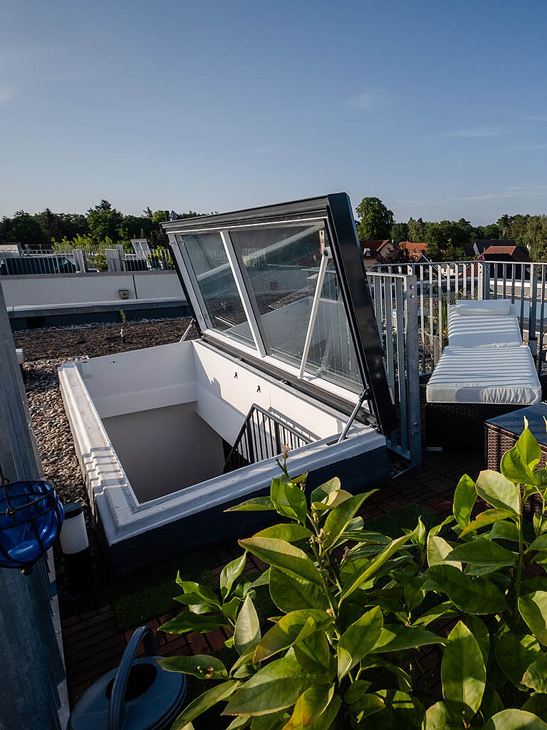 Geöffneter LAMILUX Flachdach Ausstieg auf Flachdach mit sicherem Dachzugang und integrierter Steigöffnung