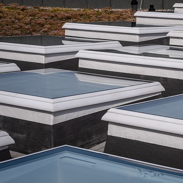 Flachdach mit mehreren quadratischen Tageslichtelementen in Reihenanordnung