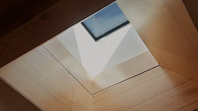 Innenansicht eines quadratischen Dachoberlichts mit weißem Schacht und einfallendem Tageslicht in einer Decke