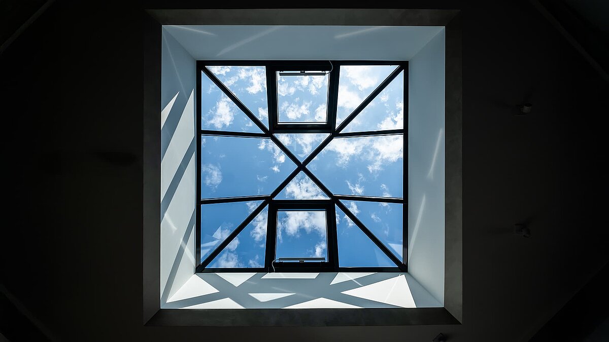 laspyramide im Neubau eines Einfamilienhauses in Wichmannsdorf, Blick auf blauen Himmel mit Wolken, lichtdurchfluteter Wohnraum.