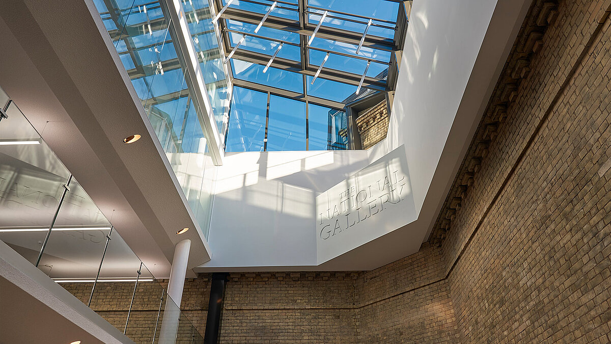 Glasdach mit Stahlrahmen über hellem Innenraum mit sichtbaren Wänden aus Beton