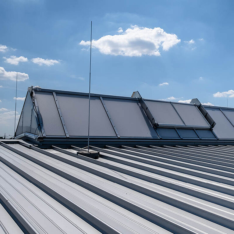 Geschlossenes LAMILUX Lichtband S RWA auf Industrie-Flachdach mit Satteldachform und durchgehender Verglasung