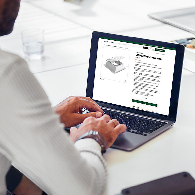 Person arbeitet an einem Laptop mit geöffneter Softwareoberfläche, die eine technische Darstellung und strukturierte Daten zur Produktplanung zeigt