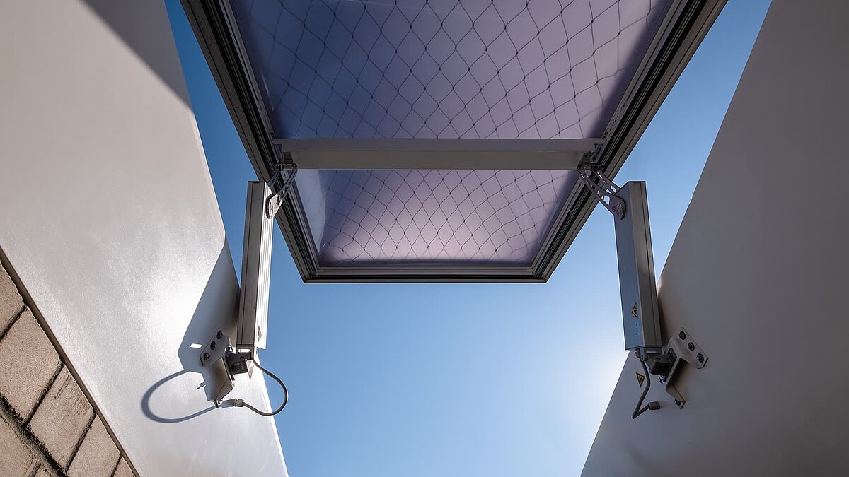 Geöffneter Flachdach-Ausstieg des Opernfundus der Hamburgischen Staatsoper mit blauem Himmel im Hintergrund.