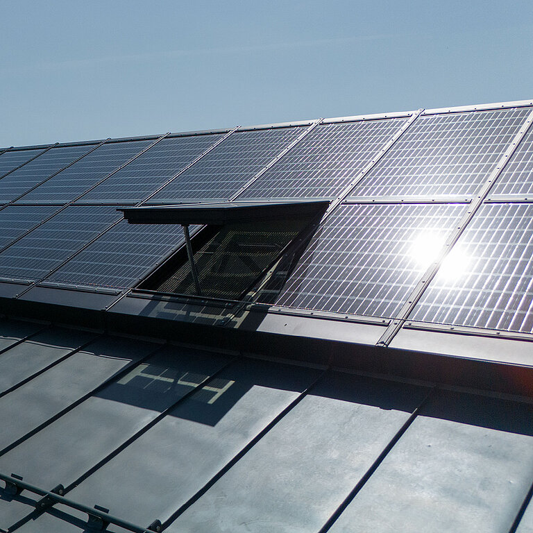 Solaranlage auf einem Glasdach mit geöffnetem Element
