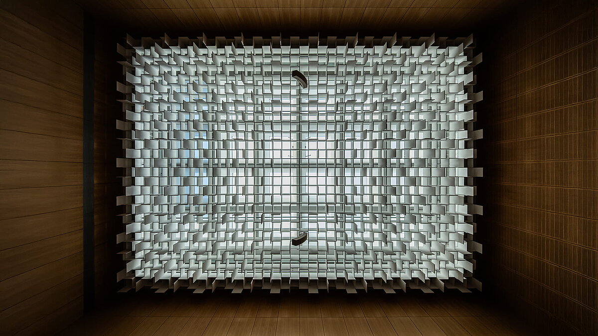 Geometrische Oberlichter-Deckenstruktur im Gerichtssaal des Landgerichts Weiden, symmetrisch von unten betrachtet.