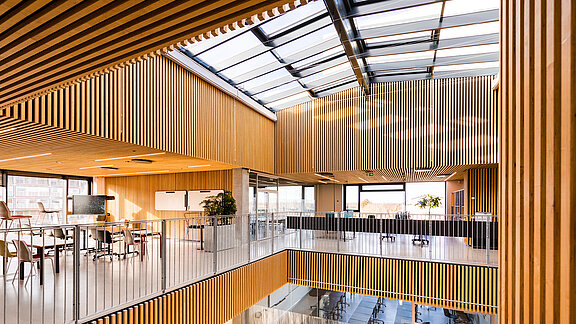 Glasdach über einem offenen Atrium mit Holzvertäfelung