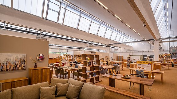 Innenansicht des alten Postbahnhofs Leipzig, umgestaltet als Möbelgeschäft mit modernem Design, natürlichen Lichtbändern und stilvollen Möbeln.