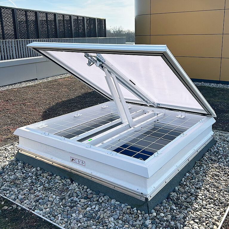 Geöffnete LAMILUX Lichtkuppel RWA auf Flachdach mit transparenter Verglasung und rechteckigem Aufsatzrahmen zur Rauch- und Wärmeabführung