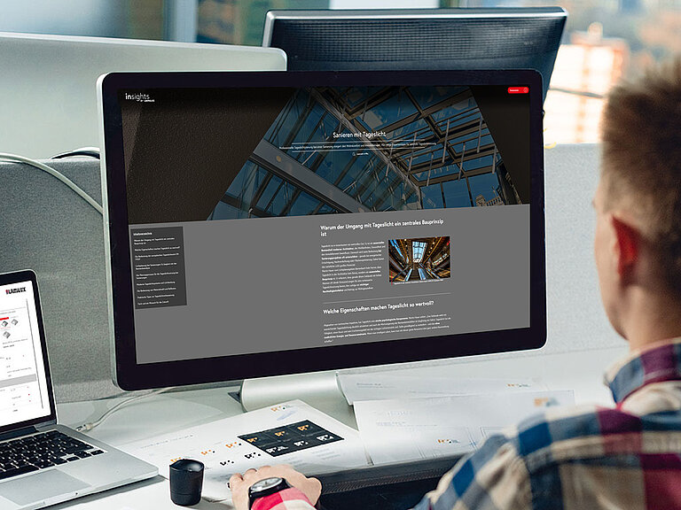 Person sitzt vor einem Desktop-Computer und bearbeitet eine 3D-Visualisierung eines Glasdachs auf dem Bildschirm