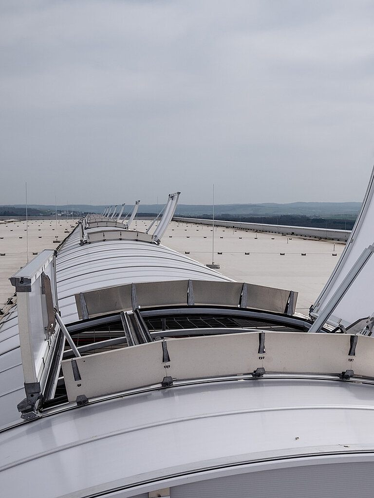 Geöffnete Dachoberlichter auf Flachdach in Reihenanordnung zur Darstellung von Brandschutz-Funktionen bei Industriegebäude