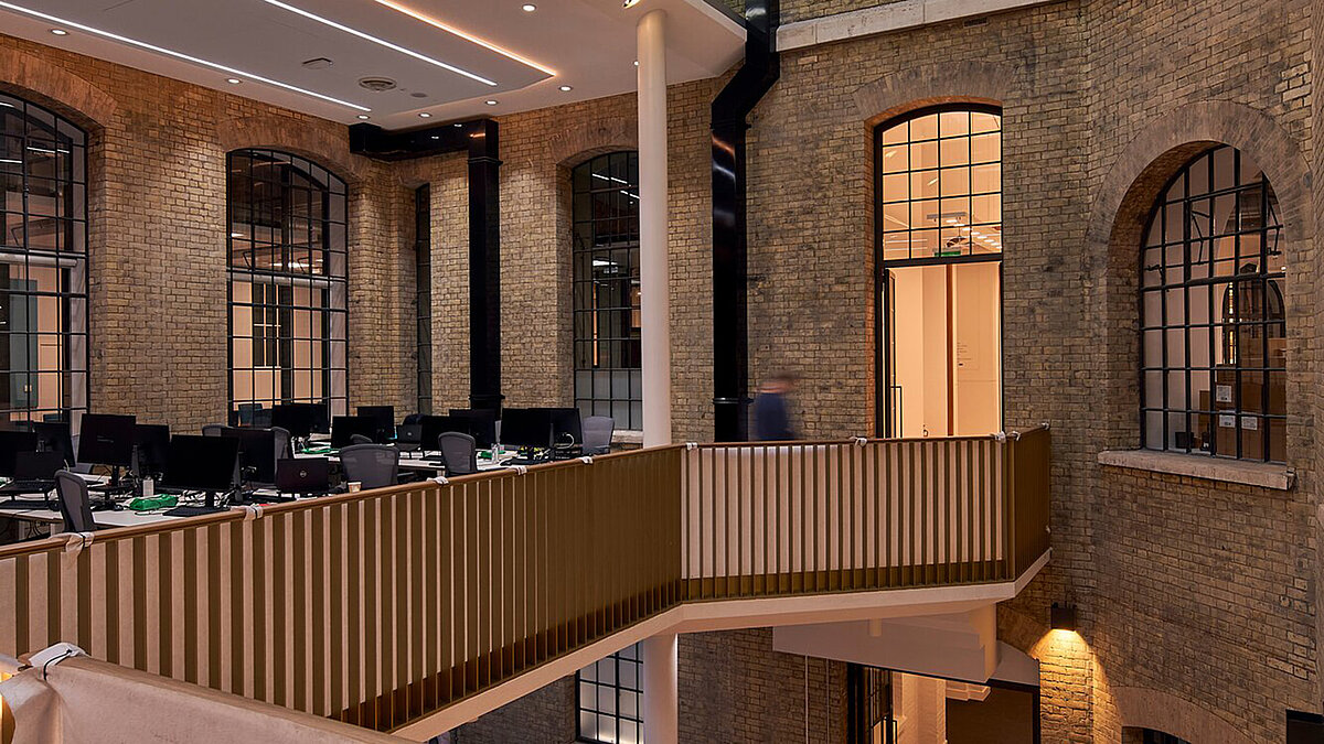 Innenraum mit Glasdach, Backsteinwänden und moderner Beleuchtung