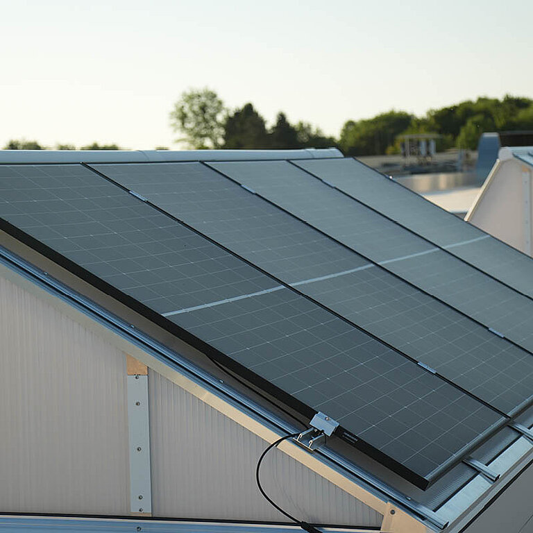 LAMILUX Lichtband mit Photovoltaik auf Flachdach mit integrierten Solarmodulen in geneigter Ausführung zur kombinierten Tageslichtnutzung und Energieerzeugung