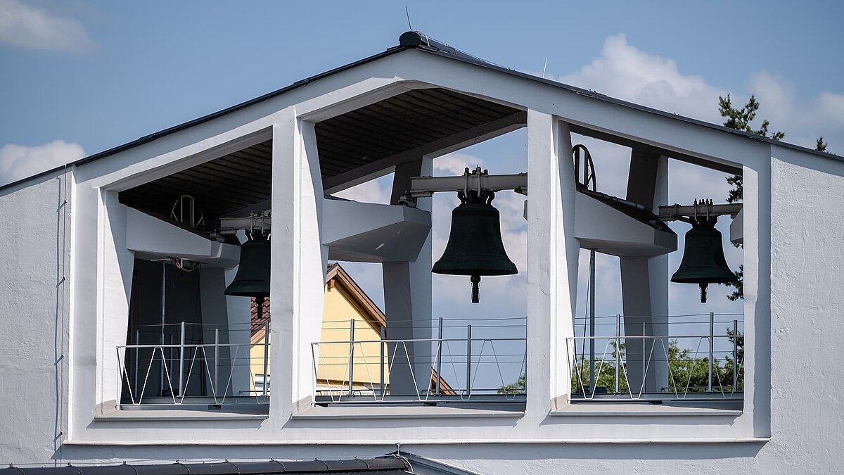 Glockenturm der Pauluskirche in Traunreut mit zwei großen Kirchenglocken.