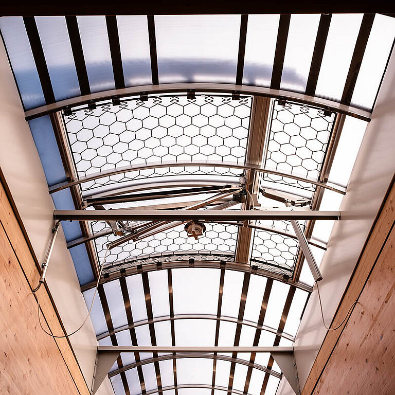 Innenansicht eines LAMILUX Lichtband B RWA mit bogenförmiger Verglasung und sichtbarer Tragkonstruktion