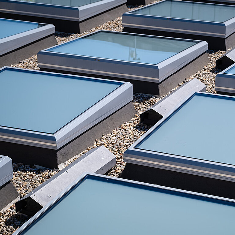 Flachdach mit rechteckigen Tageslichtelementen in regelmäßiger Anordnung