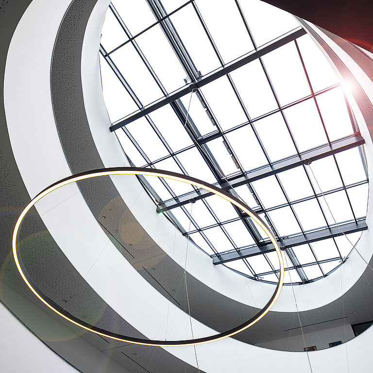 Rundes Glasdach PR60 in Atrium mit gitterförmiger Struktur und moderner Innenarchitektur.