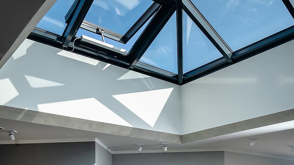 Familie beim Essen unter einer modernen Glaspyramide im Neubau eines Einfamilienhauses in Wichmannsdorf.