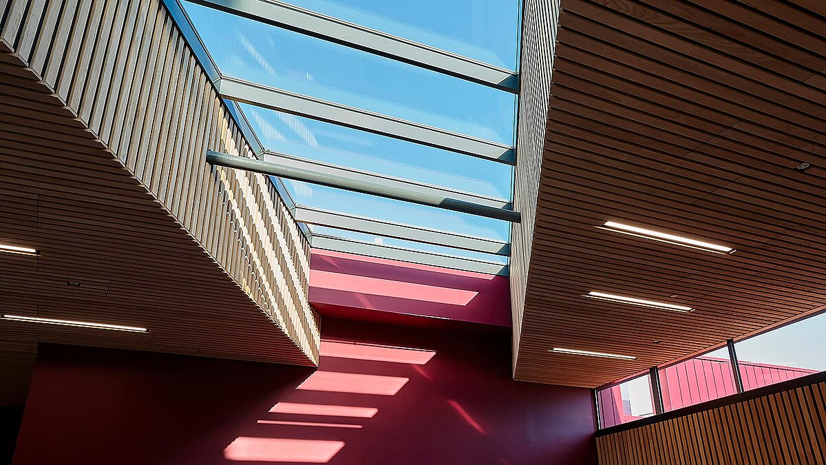 Innenansicht der Sheffield Hallam University mit LAMILUX Glasdach PR60 und modernen Holzdecken.