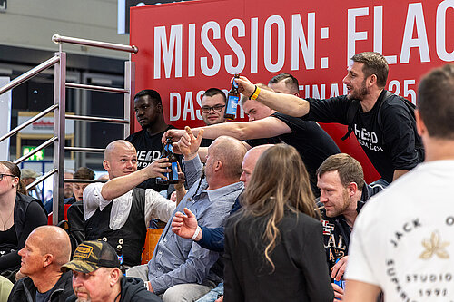 LAMILUX Mission Flachdach Teilnehmer stoßen mit Bier auf Fachmesse an