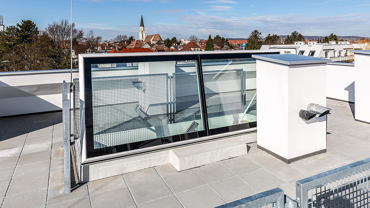 Flachdach Ausstieg in einem Wohnhaus in Korneuburg mit modernem Glasdesign und Blick auf die Stadt.