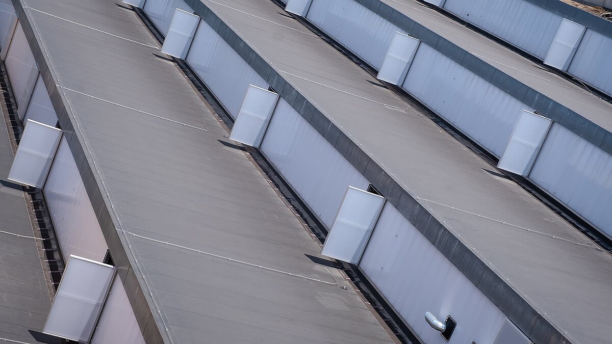 Dachansicht des alten Postbahnhofs Leipzig mit modernisierten Lichtbändern und energieeffizienter Sanierung.