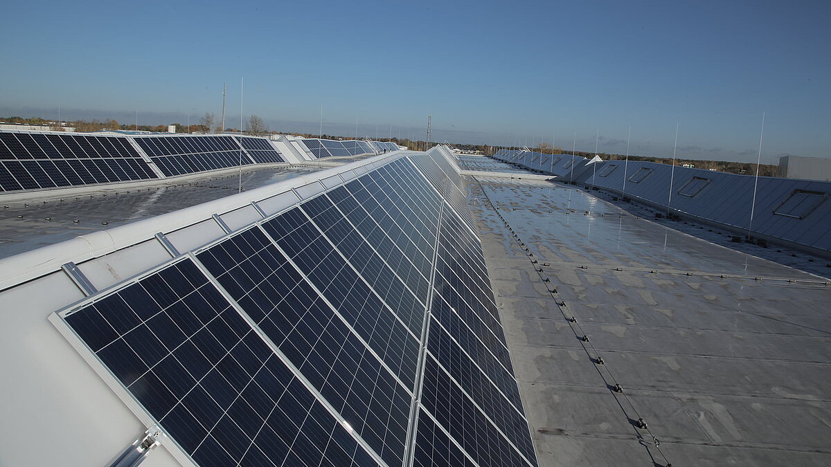 Dach des Logistikzentrums von Rhenus Logistics in Hoppegarten mit LAMILUX Lichtband S und Solarpaneelen.