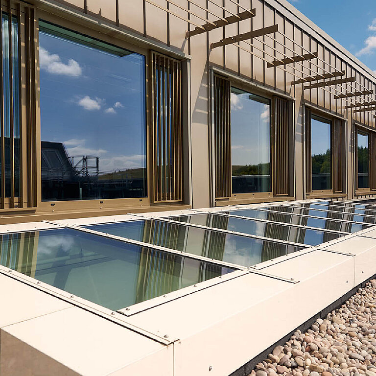 Glasdach PR60 Passivhaus als flache Dachverglasung vor moderner Fassadenarchitektur.