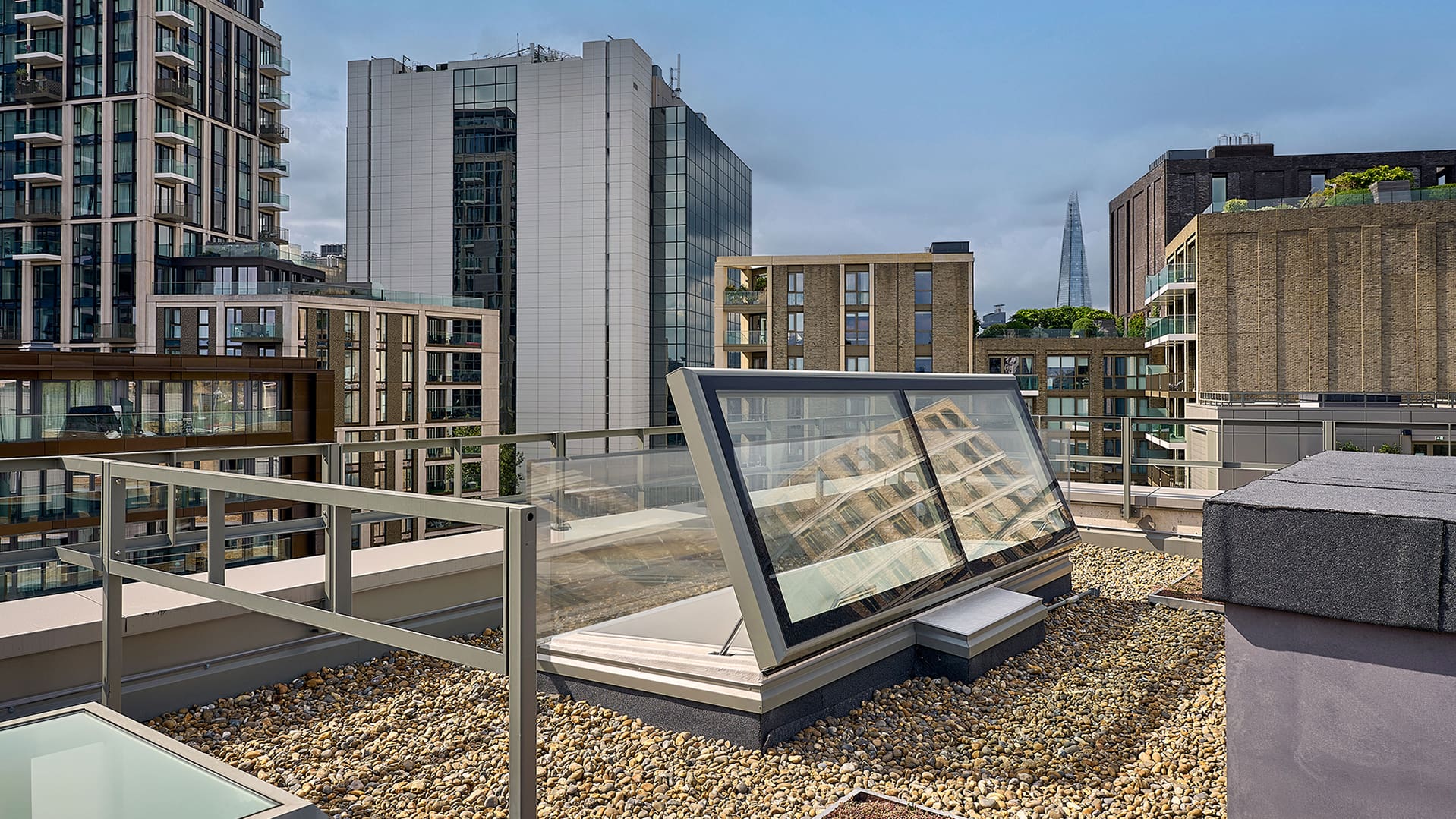 LAMILUX Flachdach Ausstieg auf dem Dach der Mulberry Academy London, umgeben von Kiesbelag und moderner Architektur