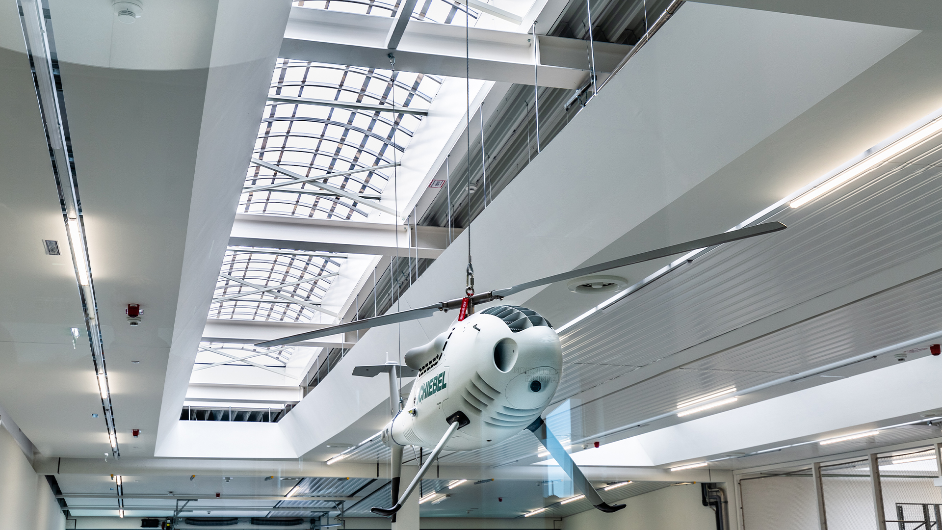 Ein Flugzeug, dass von der Decke hängt im Vordergrund vor einem Lichtband