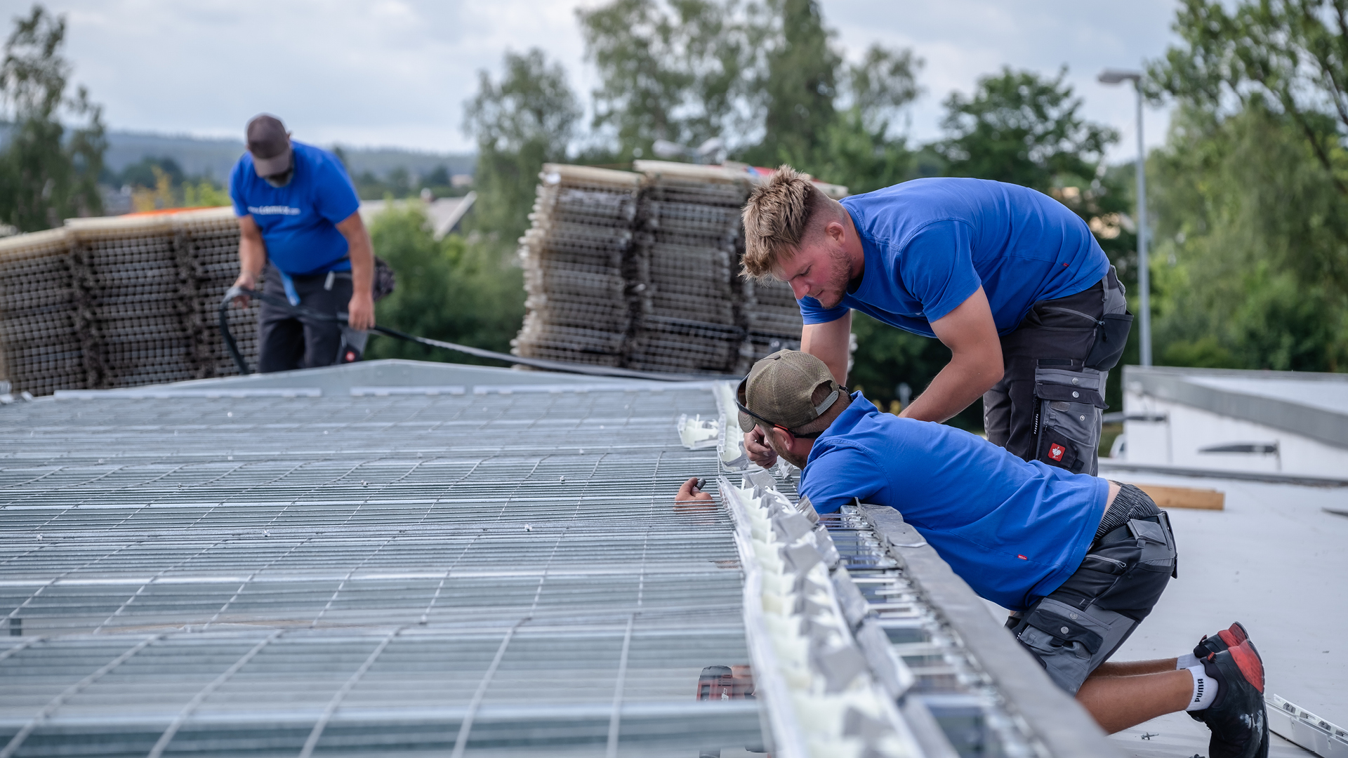 Handwerker montieren Tageslichtelemente auf einem Flachdach